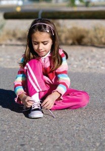 Little girl tying shoe